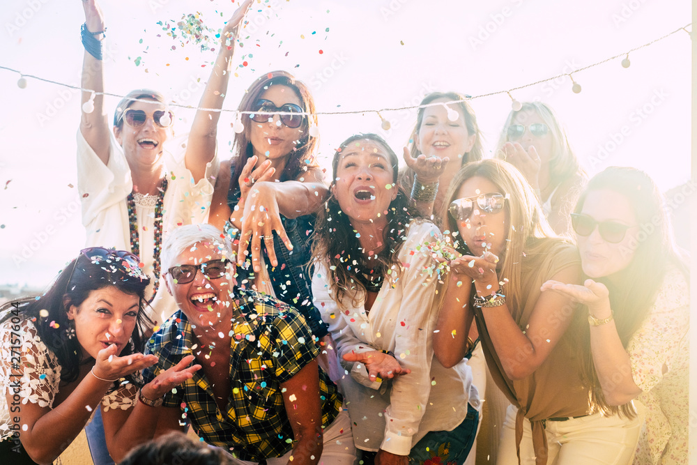 Group Of People Celebrate Together Having A Lot Of Fun Blowing Coloured Confetti Friendship